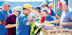 Members of the Ventura Downtown Lions Club and Ventura Rotary Club assemble backpack supplies for the Ventura County School District. (Photo by Chris Frost)